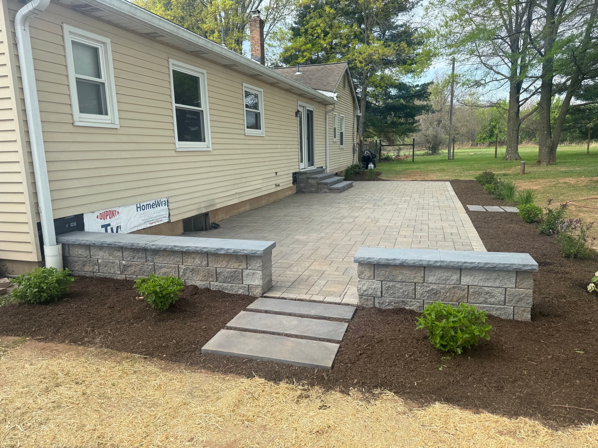 Bare Backyard Gets a Paver Patio, Seating Wall, and Fresh Landscaping image